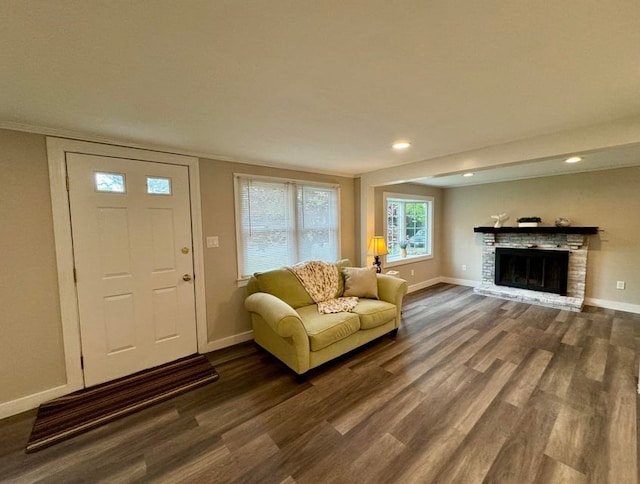 living room featuring a stone fireplace and hardwood / wood-style floors