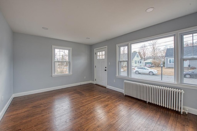 entrance foyer featuring radiator heating unit, baseboards, and dark wood-style flooring