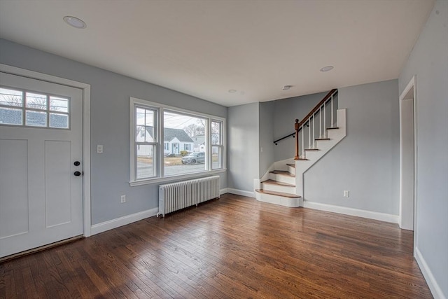 foyer with stairs, dark wood-type flooring, radiator heating unit, and baseboards