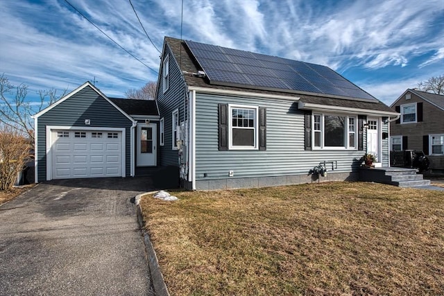 view of front of house featuring a garage, aphalt driveway, roof with shingles, roof mounted solar panels, and a front lawn