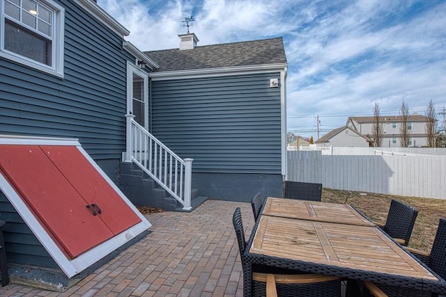 view of patio with entry steps, outdoor dining area, and fence