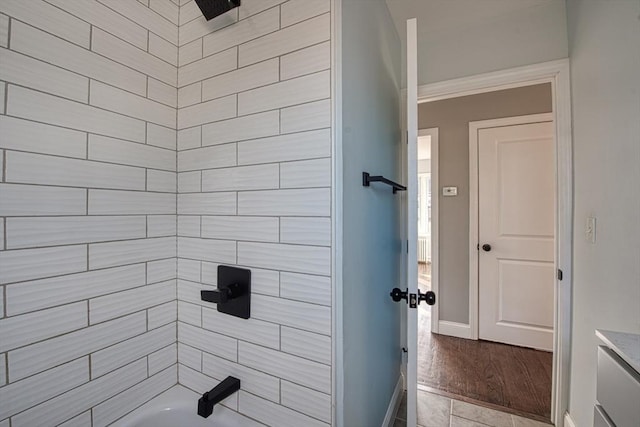 bathroom featuring tub / shower combination and baseboards