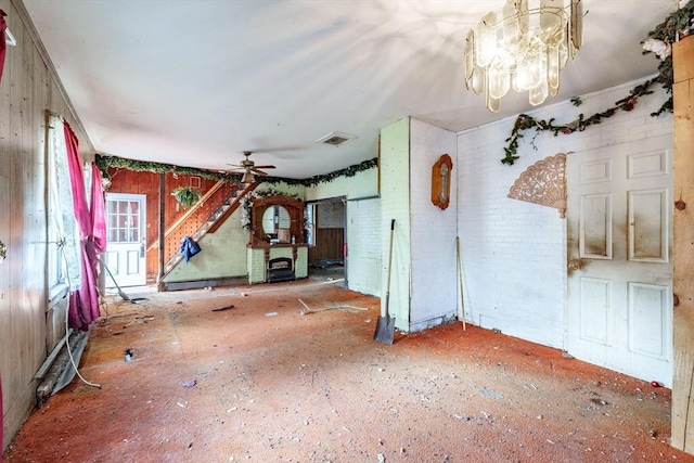 unfurnished dining area featuring ceiling fan with notable chandelier