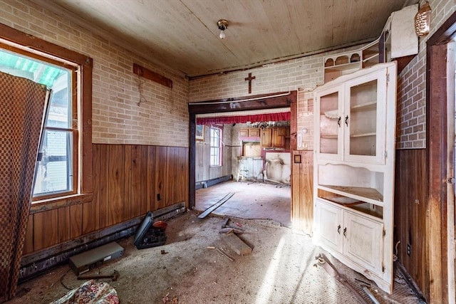 misc room featuring brick wall and wooden walls