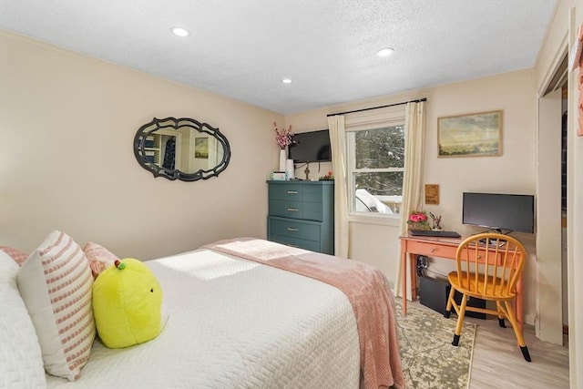 bedroom featuring a textured ceiling and light wood-type flooring