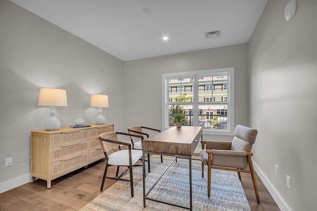 office space featuring recessed lighting, light wood finished floors, visible vents, and baseboards