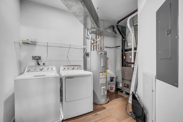 laundry area with laundry area, electric panel, water heater, wood finished floors, and washer and clothes dryer