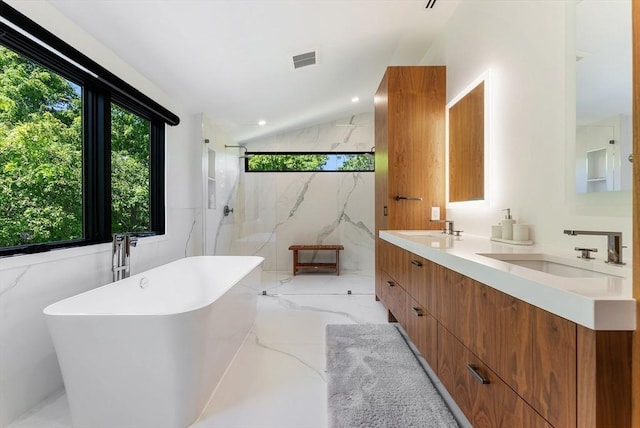 135 Beach St, Cohasset, MA 02025 - full bathroom featuring marble tiled flooring, a soaking tub, double vanity, a marble finish shower, and vaulted ceiling