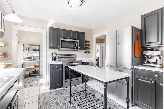 kitchen with appliances with stainless steel finishes, light countertops, and light tile patterned flooring