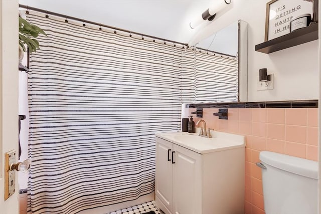 full bath featuring a shower with curtain, tile walls, toilet, and vanity