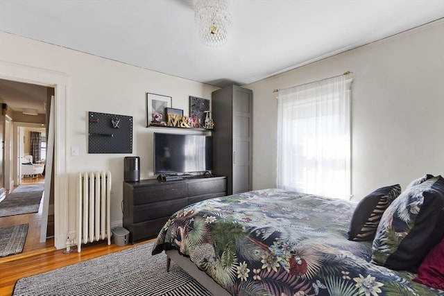 bedroom featuring radiator heating unit and wood finished floors