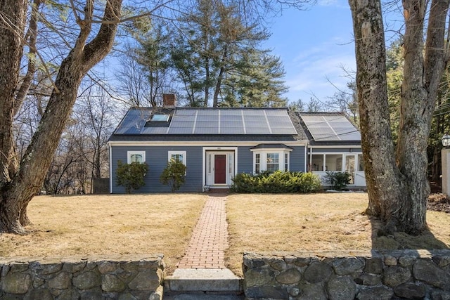 view of front facade with solar panels and a chimney