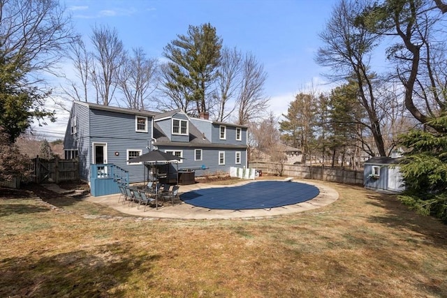 back of house featuring fence, a shed, a wooden deck, a chimney, and an outdoor structure