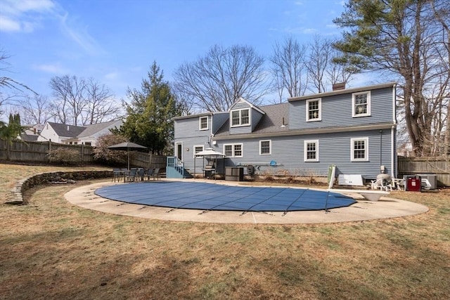 back of house featuring a patio area, a fenced in pool, a lawn, and fence