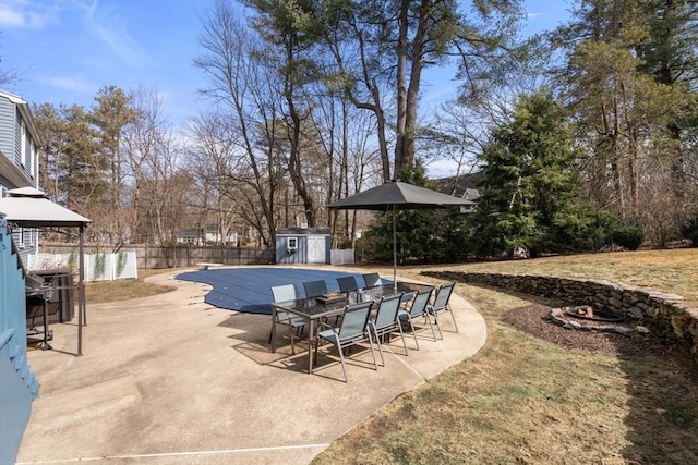 view of pool with a patio area, a storage unit, an outdoor structure, and fence