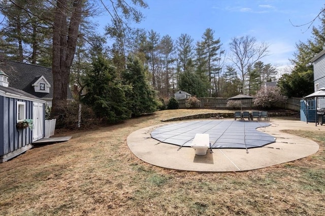 view of yard with a fenced in pool, a patio, an outdoor structure, and a fenced backyard