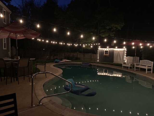 pool at twilight with a fenced in pool, a patio area, and fence