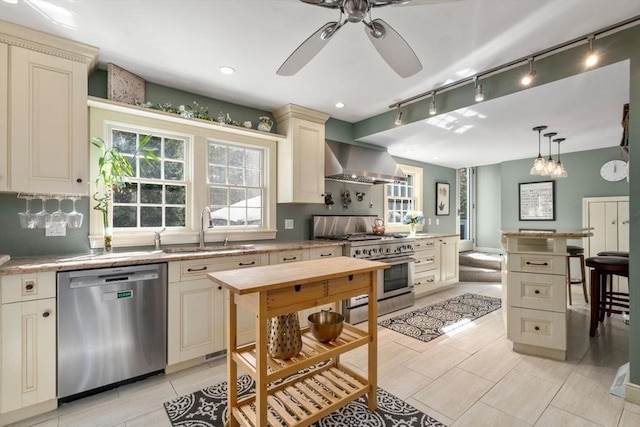 kitchen featuring a sink, cream cabinets, wall chimney exhaust hood, and stainless steel appliances