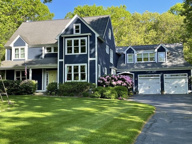 view of front of house featuring driveway, a garage, and a front yard