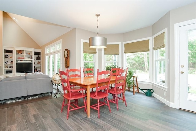 dining room featuring baseboards, wood finished floors, and vaulted ceiling