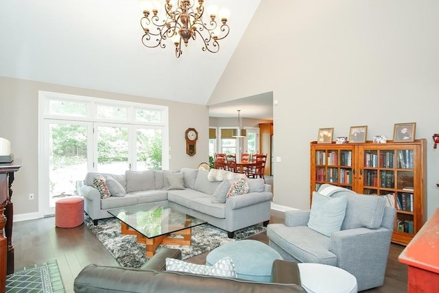 living area featuring dark wood-style flooring, a notable chandelier, high vaulted ceiling, and baseboards