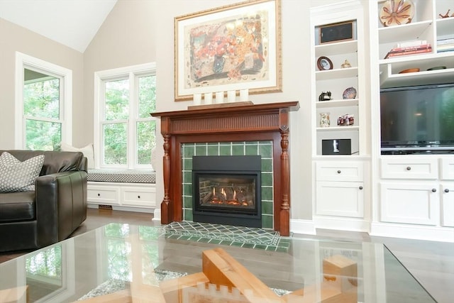 living room with vaulted ceiling and a tiled fireplace