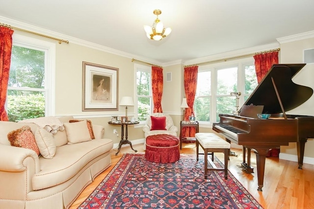 living area featuring crown molding, light wood finished floors, baseboards, visible vents, and an inviting chandelier