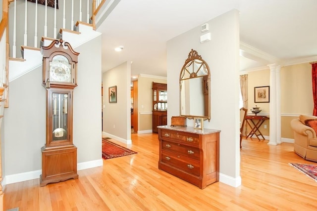 hall with baseboards, stairway, and light wood finished floors
