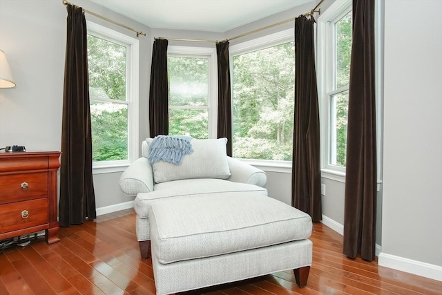 living area with dark wood-style flooring and baseboards