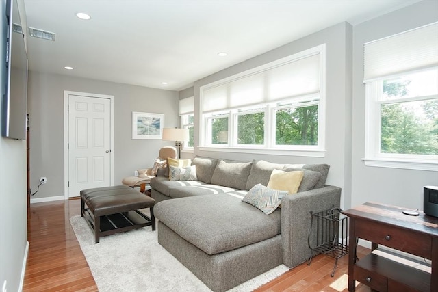 living room featuring baseboards, visible vents, light wood-style flooring, and recessed lighting