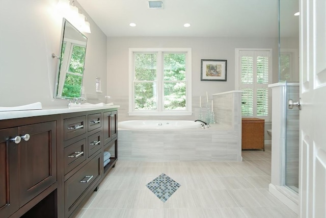 full bathroom featuring visible vents, tile patterned floors, vanity, a stall shower, and a garden tub