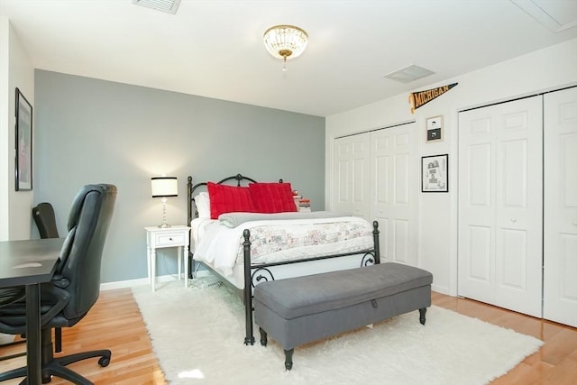 bedroom featuring baseboards, visible vents, and light wood-style floors