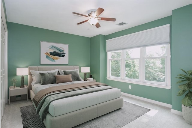 carpeted bedroom with a ceiling fan, baseboards, and visible vents