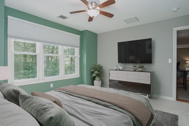 carpeted bedroom featuring baseboards, visible vents, and ceiling fan