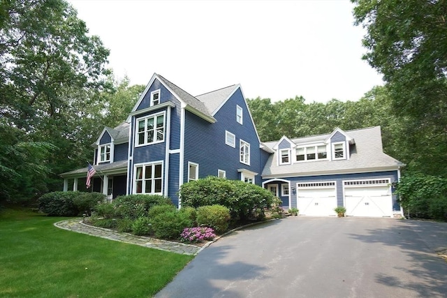 view of home's exterior featuring driveway, a garage, and a lawn