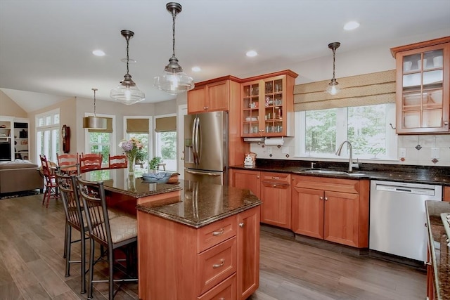 kitchen with dishwasher, a sink, stainless steel refrigerator with ice dispenser, and wood finished floors