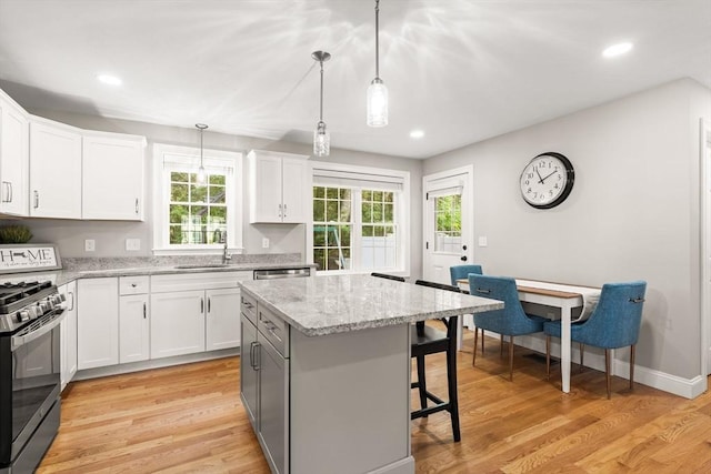 30 Oak Meadow Pl Unit 30, Bridgewater, MA 02324 - kitchen featuring stainless steel gas range oven, a kitchen breakfast bar, healthy amount of natural light, white cabinets, and recessed lighting