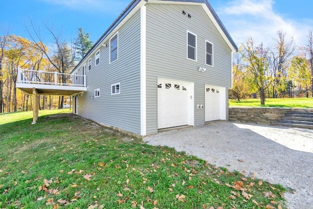 view of side of home featuring a wooden deck, a lawn, aphalt driveway, and a garage