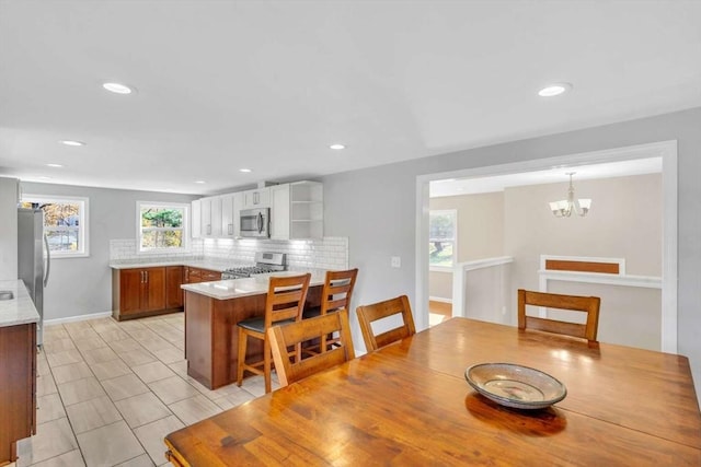 dining room with an inviting chandelier, a healthy amount of sunlight, and recessed lighting