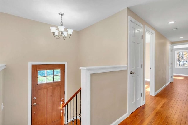 entryway featuring hardwood / wood-style flooring, an inviting chandelier, recessed lighting, and baseboards
