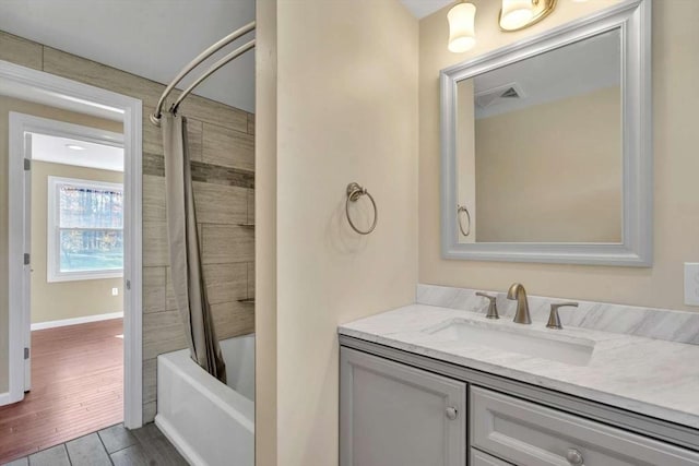 bathroom with baseboards, visible vents, shower / tub combo, wood finished floors, and vanity