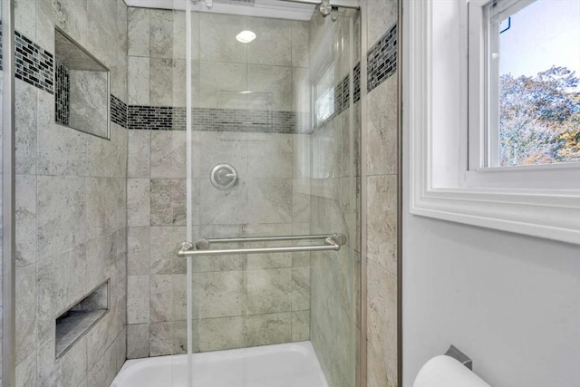 full bath featuring toilet and a tile shower