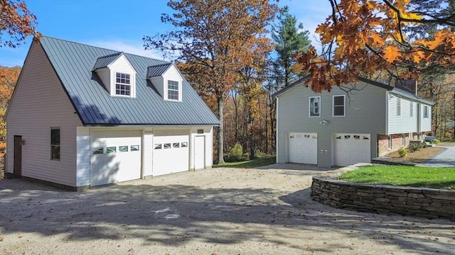 view of property exterior featuring a detached garage and metal roof