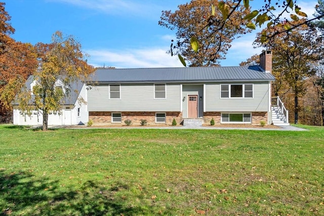 bi-level home featuring a chimney, stairway, metal roof, and a front yard