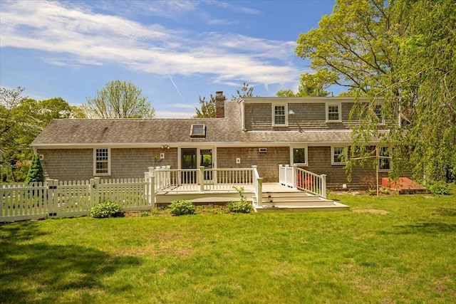 rear view of property with a chimney, a deck, and roof with shingles
