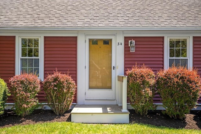 property entrance featuring roof with shingles
