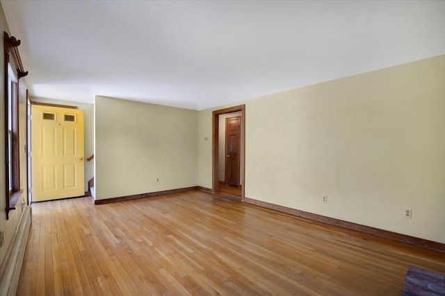 unfurnished room featuring light wood-style floors, baseboards, and baseboard heating