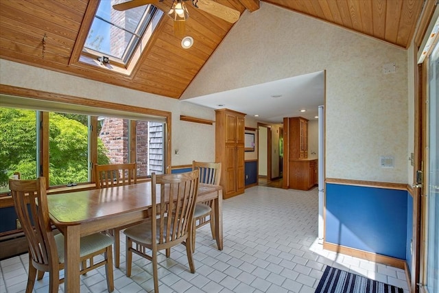 dining area featuring wooden ceiling, a ceiling fan, a skylight, high vaulted ceiling, and brick patterned flooring
