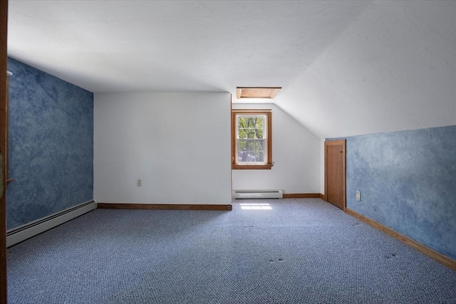 additional living space with a baseboard heating unit, vaulted ceiling, carpet, and baseboards