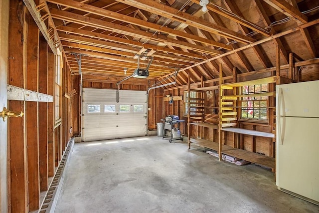 garage with freestanding refrigerator and a garage door opener